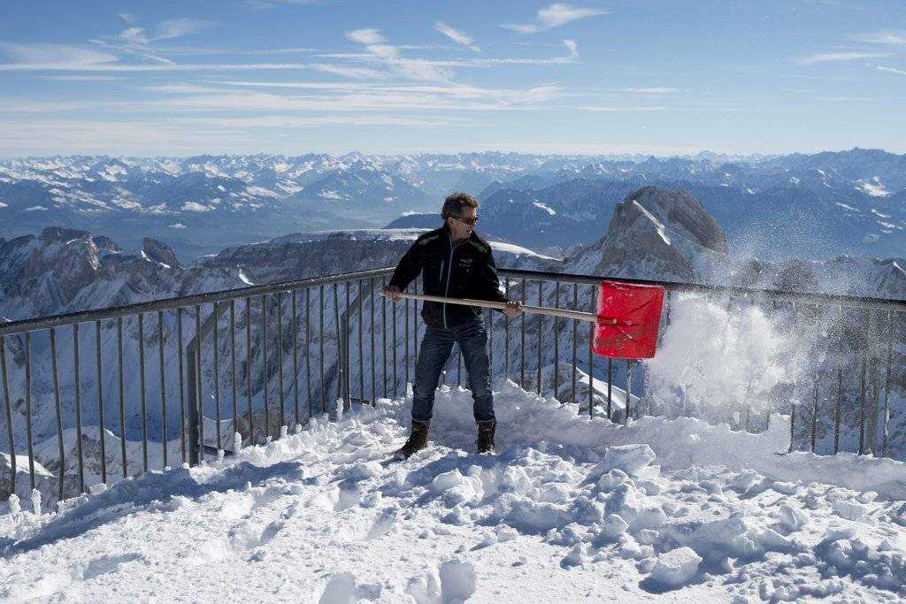 Gust Broger schaufelt Schnee auf dem Gipfel, am Freitag, 24. Oktober 2014, auf dem Saentis (2501,9 Meter). (KEYSTONE/Gian Ehrenzeller)