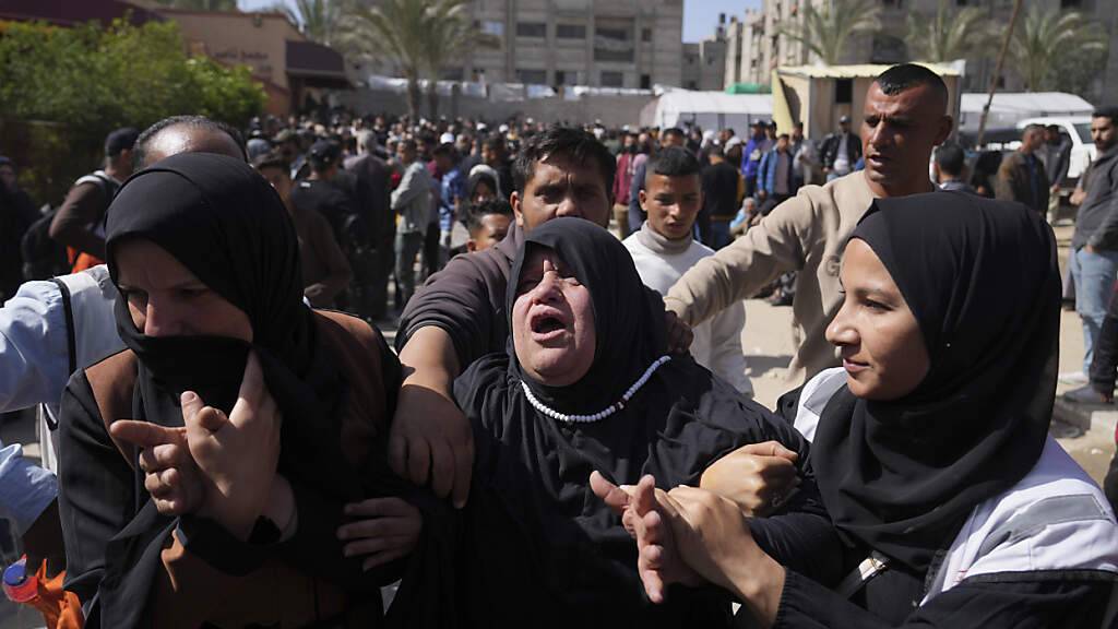 ARCHIV - Menschen trauern bei der Beerdigung von acht Rettungssanitätern des Roten Halbmonds, die eine Woche nach einem israelischen Angriff in Rafah geborgen wurden. Foto: Abdel Kareem Hana/AP/dpa