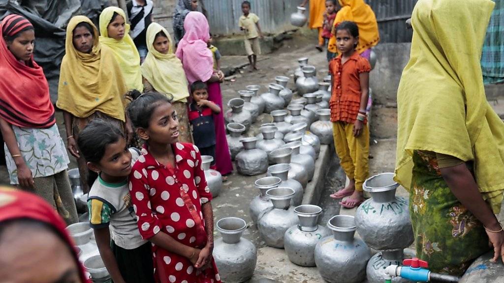 Nach Bangladesch geflohene Rohingya-Frauen und Kinder stehen an für Wasser