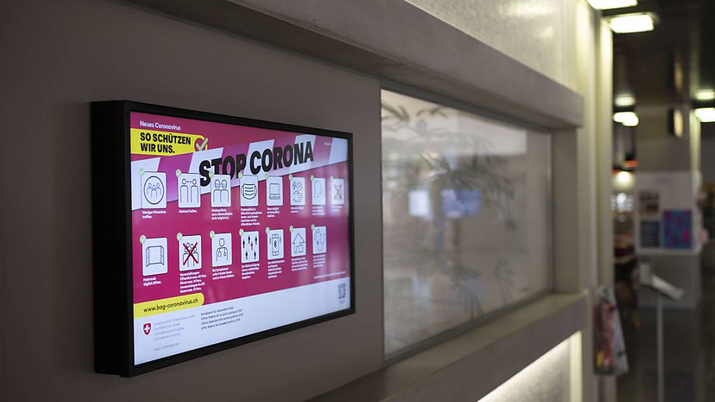 Auf einem Bildschirm wird in einer Schule auf die Corona-Regeln des Bundesamts für Gesundheit hingewiesen. (Archivbild)