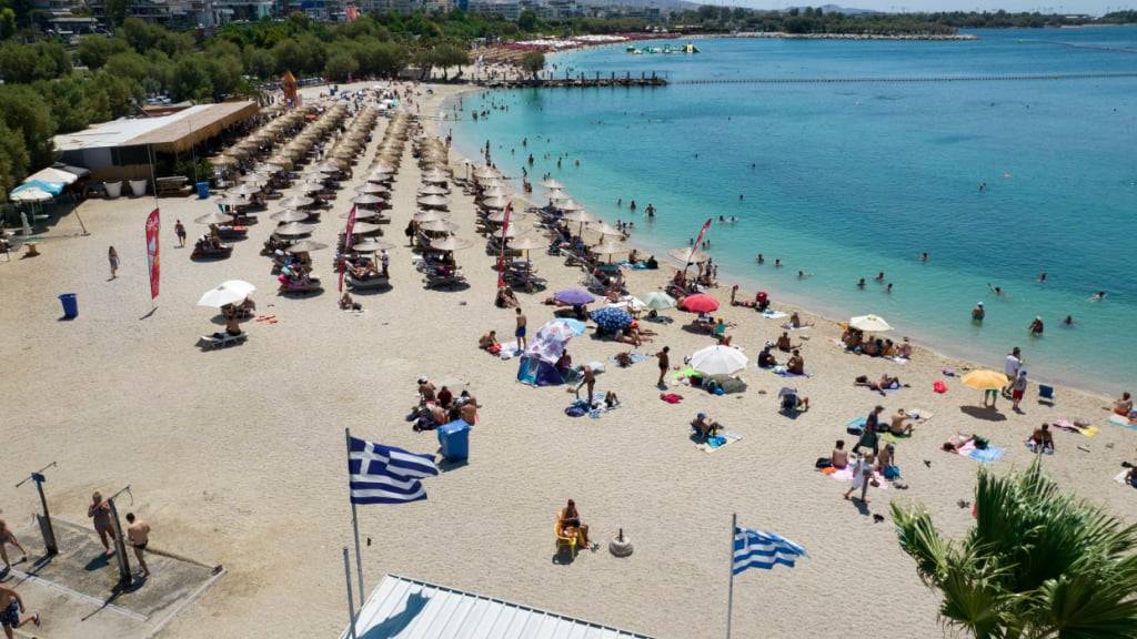 ARCHIV - Menschen an einem Strand im Vorort Alimos in Athen. Foto: Yorgos Karahalis/AP/dpa/Archivbild