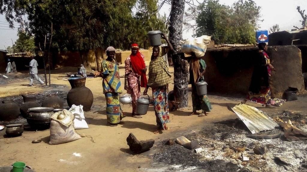 Frauen verlassen mit ihren Habseligkeiten ein von Boko Haram angegriffenes Dorf. (Archiv)