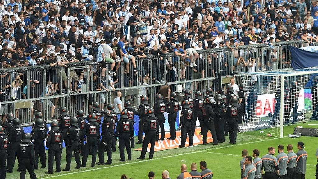 Polizisten und Ordner mussten in der Relegations-Rückspiel des TSV 1860 München gegen Jahn Regensburg in der 80. Minute das Spielfeld sichern