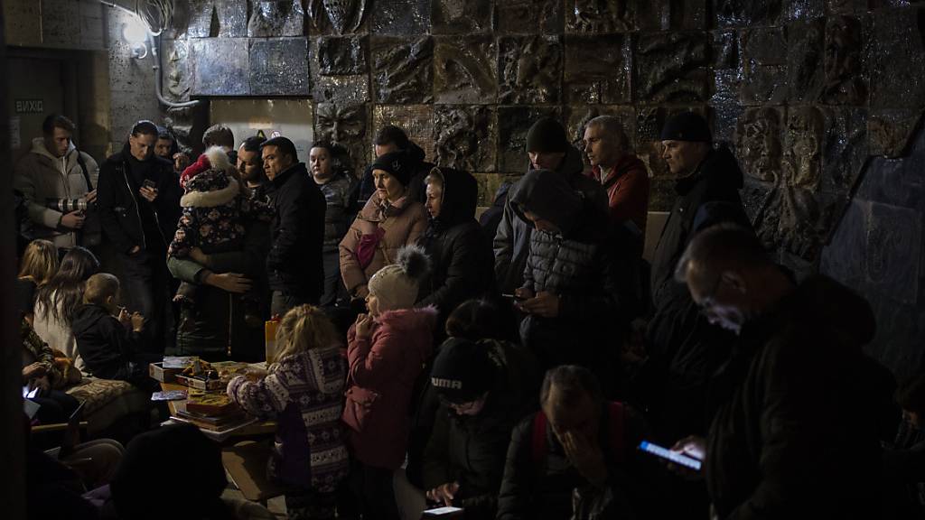 Menschen versammeln sich während eines Luftangriffs in einem Keller in Lwiw, der als Luftschutzbunker dient.