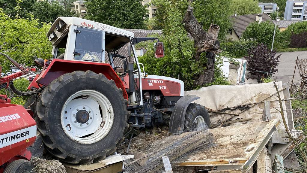 Traktor rollt Hang hinunter und landet in einem Garten