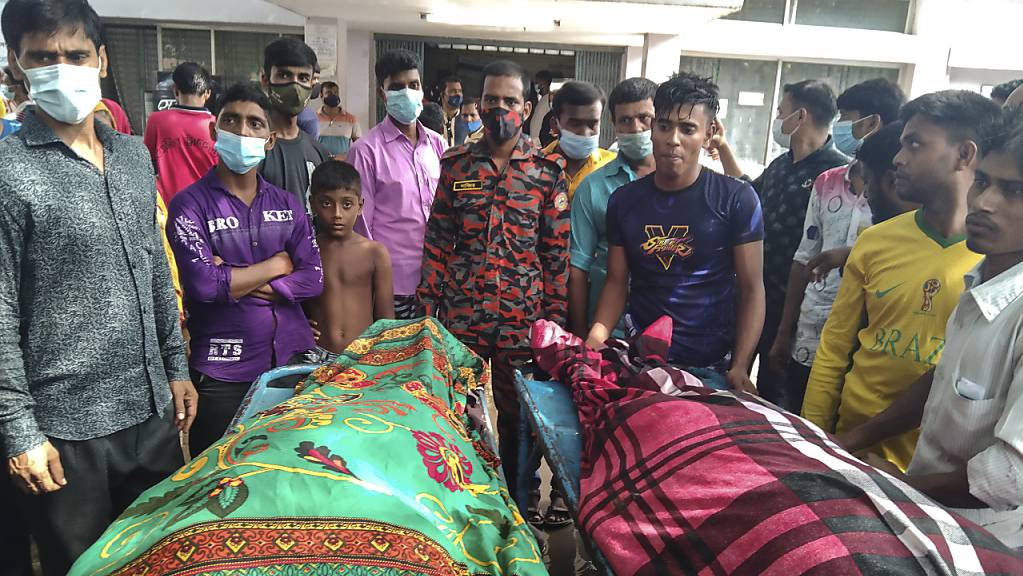 Personen stehen um die Leichen von Opfern, die durch einen Blitzeinschlag starben. Mindestens 15 Gäste sind auf dem Weg zu einer Hochzeitsfeier in Bangladesch vom Blitz getroffen worden und gestorben.