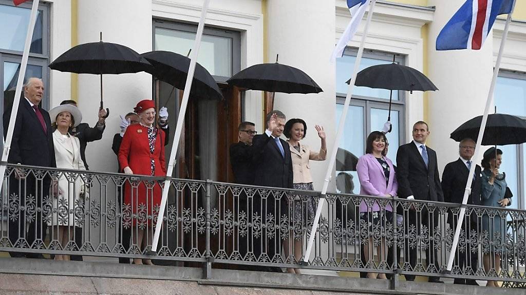 Trotz Regen in Feierlaune: Der finnische Präsident Sauli Niinistö, seine Frau Jenni Haukio (Mitte) und ihre hochrangigen Gäste.