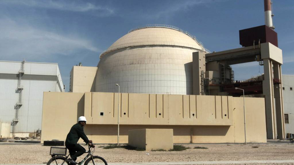 ARCHIV - Ein Mann fährt mit dem Fahrrad an dem Reaktorgebäude des Kernkraftwerks Bushehr im Iran vorbei. Foto: Majid Asgaripour/AP/dpa