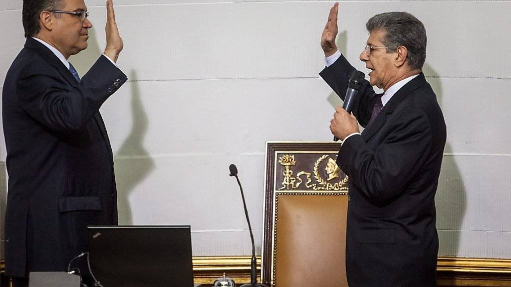 Der neue Parlamentspräsident Venezuelas, Henry Ramos, bei der Vereidigung der Parlamentsabgeordneten.(Archiv) Mit der umstrittenen Vereidigung dreier Parlamentarier, deren Wahl vom Obersten Gericht zuvor suspendiert worden war, errang die konservative Opposition eine Zweidrittel-Mehrheit.