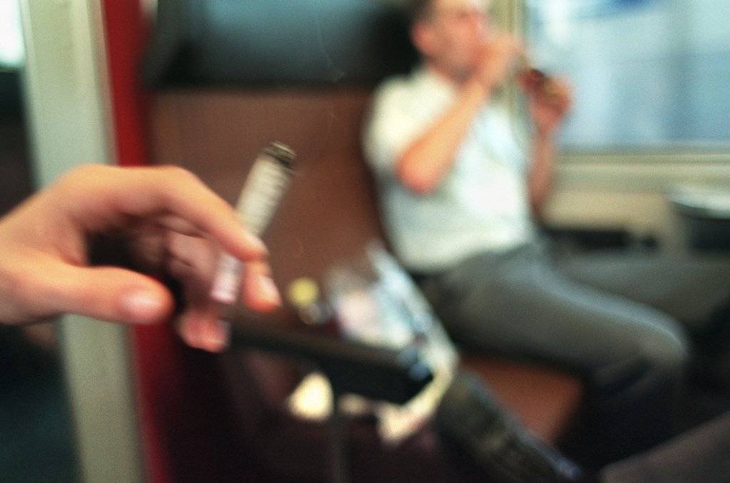 Ein Jugendlicher raucht auf einer Zugfahrt einen Joint, aufgenommen am 26. August 2003. (KEYSTONE/Martin Ruetschi)