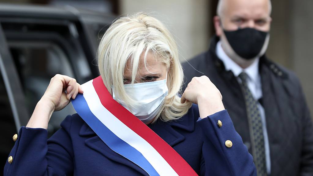 Die Vorsitzende der rechtspopulistischen Partei Rassemblement National, Marine le Pen, trägt eine Gesichtsmaske, als sie zu einer Zeremonie an der Statue der Jeanne d'Arc eintrifft.