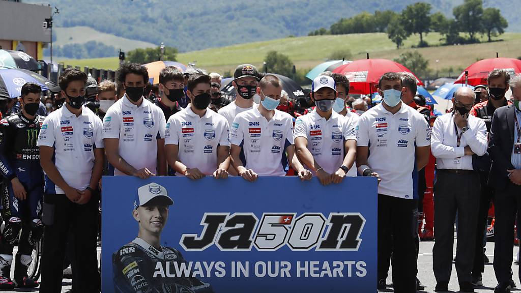 Teammitglieder und Fahrer gedenken dem verstorbenen Jason Dupasquier.