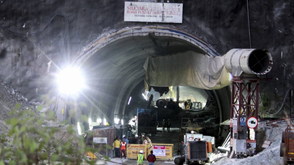 ARCHIV - Sicherheitspersonal bewacht den Eingang eines im Bau befindlichen Straßentunnels, der im indischen Bundesstaat Uttarakhand eingestürzt ist. Foto: AP/dpa