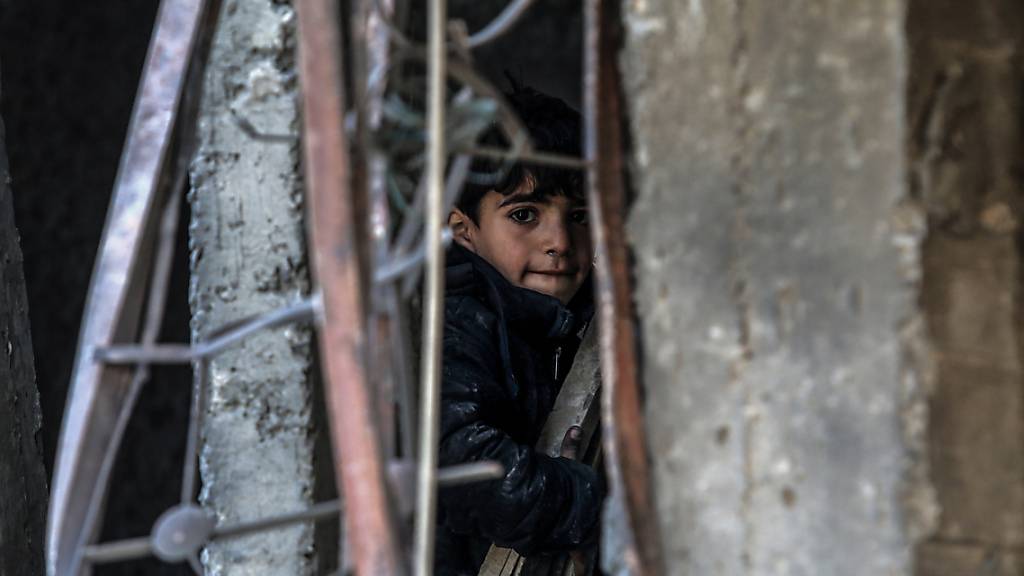 dpatopbilder - Ein palästinensisches Kind inspiziert beschädigte Gebäude nach israelischen Luftangriffen in Rafah. Foto: Abed Rahim Khatib/dpa