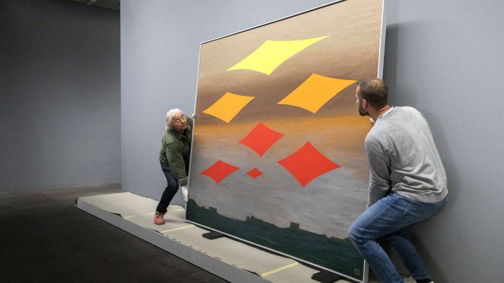 Zwei Mitarbeitende bringen das Werk «Neue Sterne» von Meret Oppenheim in die Ausstellungsräume des Kunstmuseums Bern.