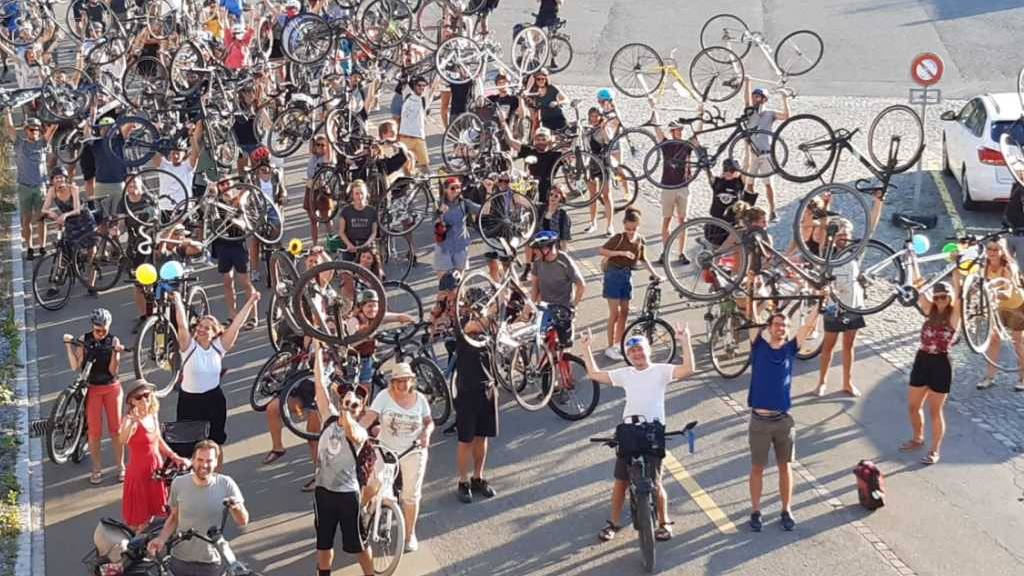 Gut gelaunte Teilnehmerinnen und Teilnehmer der ersten «Critical Mass» in St. Gallen posieren mit ihren Velos bei der St.-Otmar-Brücke.