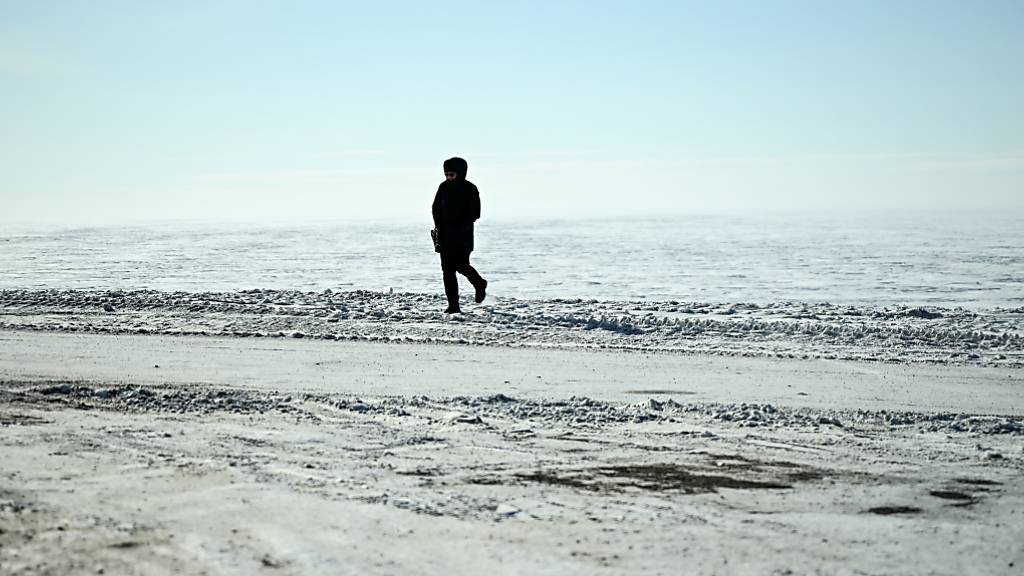Ein Mann am Rande des Polarmeers in Tuktoyaktuk in der Arktis. Foto: Britta Pedersen/dpa