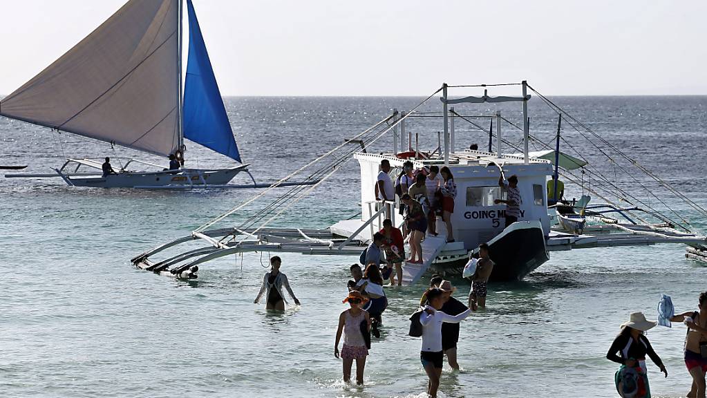 ARCHIV - Eine Gruppe von Touristen kommt am Strand von Boracay an. Die Philippinen werden bald wieder ihre Grenzen für vollständig geimpfte Urlauber aus «grünen» Ländern mit einer hohen Impfquote und niedrigen Infektionszahlen öffnen. Das teilte der Präsidentensprecher Karlo Nograles am Freitag mit. Foto: Alejandro Ernesto/dpa