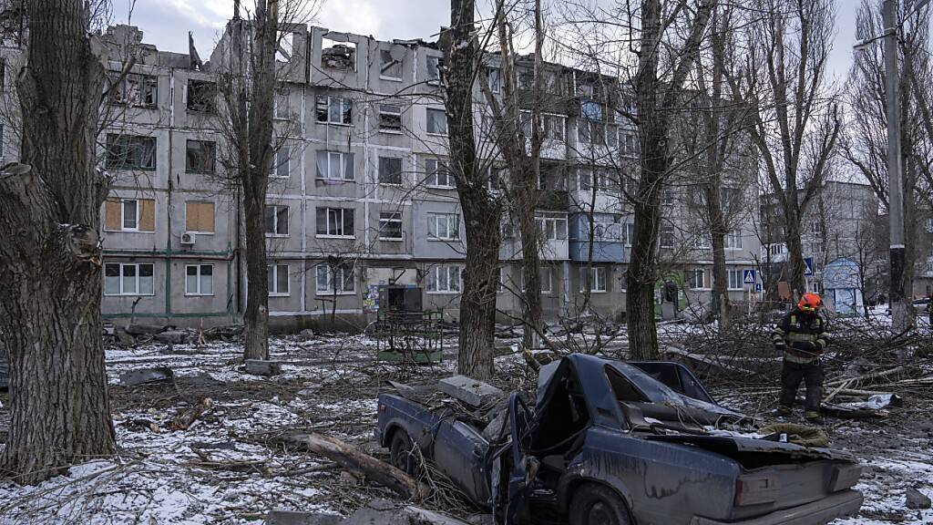 ARCHIV - Ein Rettungsarbeiter räumt die Trümmer eines Wohnhauses weg, das durch eine Rakete zerstört wurde. Foto: Evgeniy Maloletka/AP/dpa