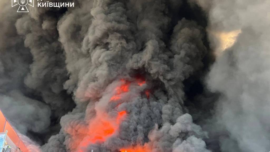 HANDOUT - Auf diesem vom ukrainischen Rettungsdienst zur Verfügung gestellten Foto löschen Feuerwehrleute nach einem russischen Drohnenangriff in der Nähe von Kiew einen Brand in einem Lagerhaus. Foto: Ukrainian Emergency Service/via Ap/dpa