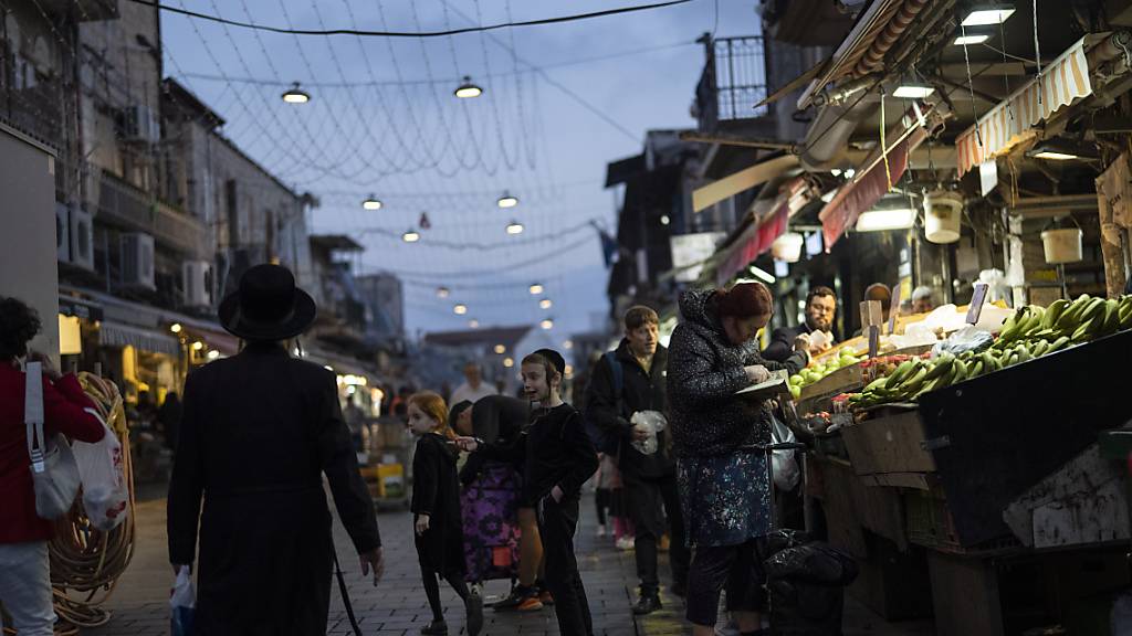 Eine Frau kauft Obst an einem Strand auf dem Mahane Yehuda-Markt. Israel lobte seine Luftabwehr angesichts eines beispiellosen Angriffs durch den Iran. Die Systeme hätten 99 Prozent der mehr als 300 Drohnen und Raketen, die auf sein Territorium abgeschossen wurden, abgewehrt. Foto: Leo Correa/AP/dpa