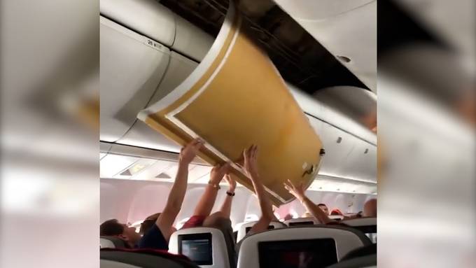 Passagiere müssen Flugzeugdecke halten