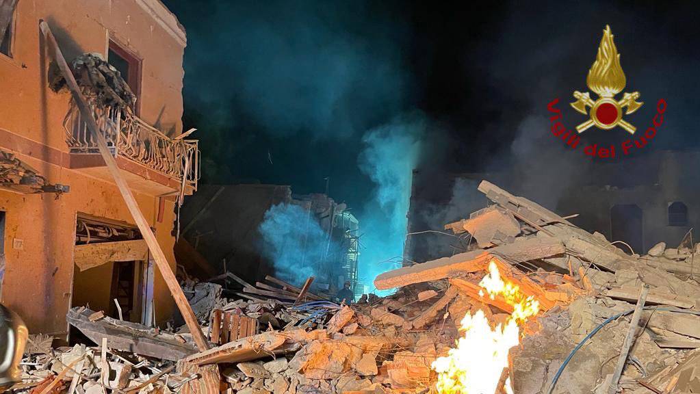 HANDOUT - Rauch und Flammen kommen aus den Trümmern eines Wohnhauses. Nach einer Explosion ist ein Wohnhaus auf Sizilien eingestürzt - mehrere Menschen werden vermisst. Foto: Feuerwehr Ravanusa/via Twitter/dpa