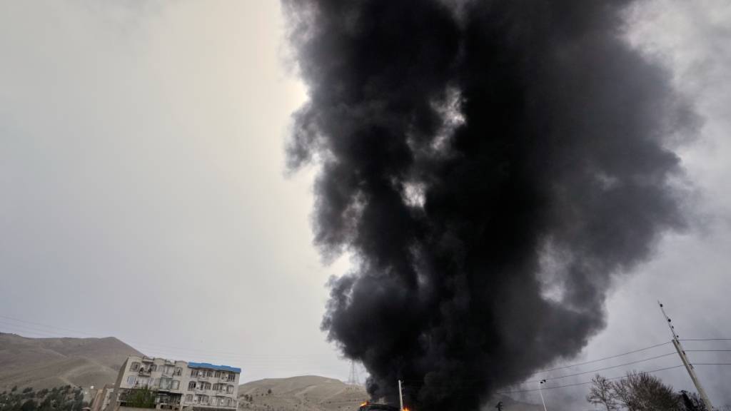 Eine dicke Rauchwolke, die von einem amerikanisch-israelischen Angriff auf ein Öllager am späten Samstag stammt, ist am bewölkten Himmel über Teheran zu sehen. Foto: Vahid Salemi/AP/dpa