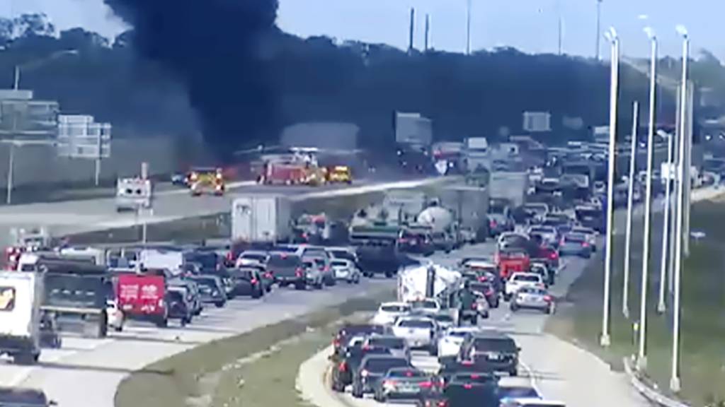 SCREENSHOT - Auf diesem Videostandbild des Verkehrsministeriums arbeiten Polizisten der Florida Highway Patrol an der Absturzstelle eines Kleinflugzeugs. Foto: Uncredited/FDOT/Florida Highway Patrol/AP/dpa - ACHTUNG: Nur zur redaktionellen Verwendung im Zusammenhang mit der aktuellen Berichterstattung und nur mit vollständiger Nennung des vorstehenden Credits