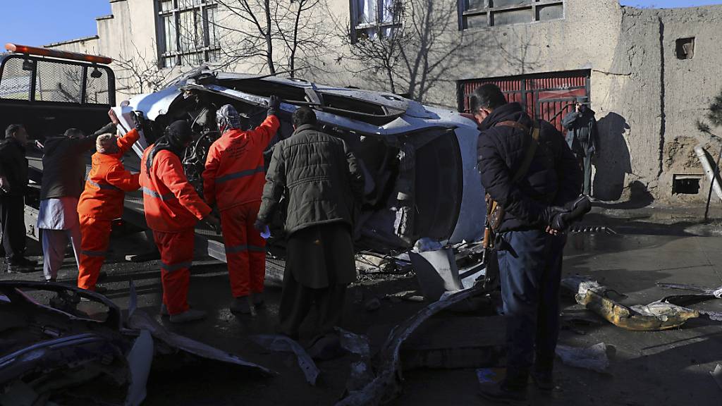 Afghanische Sicherheitskräfte und Gemeindearbeiter entfernen ein beschädigtes Fahrzeug nach einem Bombenanschlag. Bei einem erneuten Anschlag in der afghanischen Hauptstadt Kabul sind mindestens fünf Menschen getötet worden, vier von ihnen Ärzte. Foto: Rahmat Gul/AP/dpa