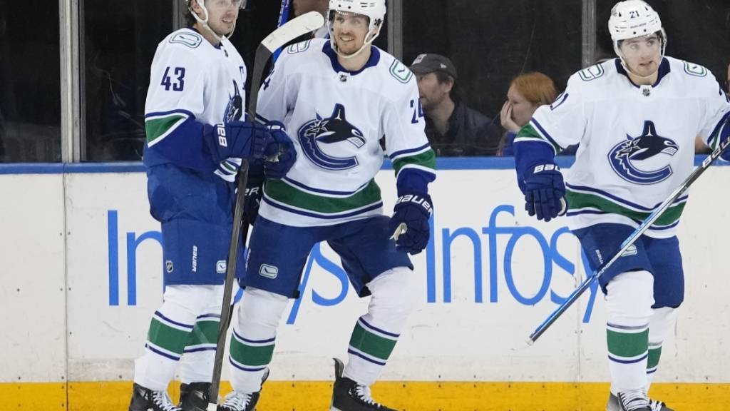 Pius Suter (Mitte) feiert mit seinen Teamkollegen Nils Höglander (rechts) und Quinn Hughes den Sieg in New York