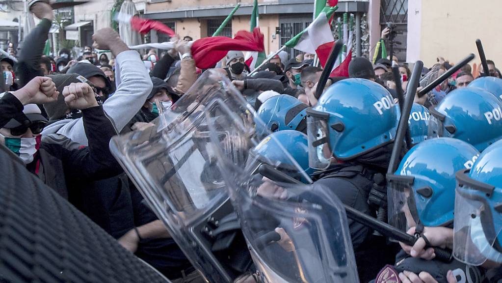 Demonstranten stoßen bei einem Protest gegen die Corona-Maßnahmen, die von Premierminister Conte erlassen wurden, mit Polizisten aneinander. Foto: Roberto Monaldo/LaPresse/AP/dpa