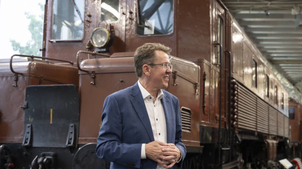Bundesrat Albert Rösti spricht vor einer Lokomotive im Verkehrshaus Luzern über das grosse Ausbauprojekt «Verkehr '45».