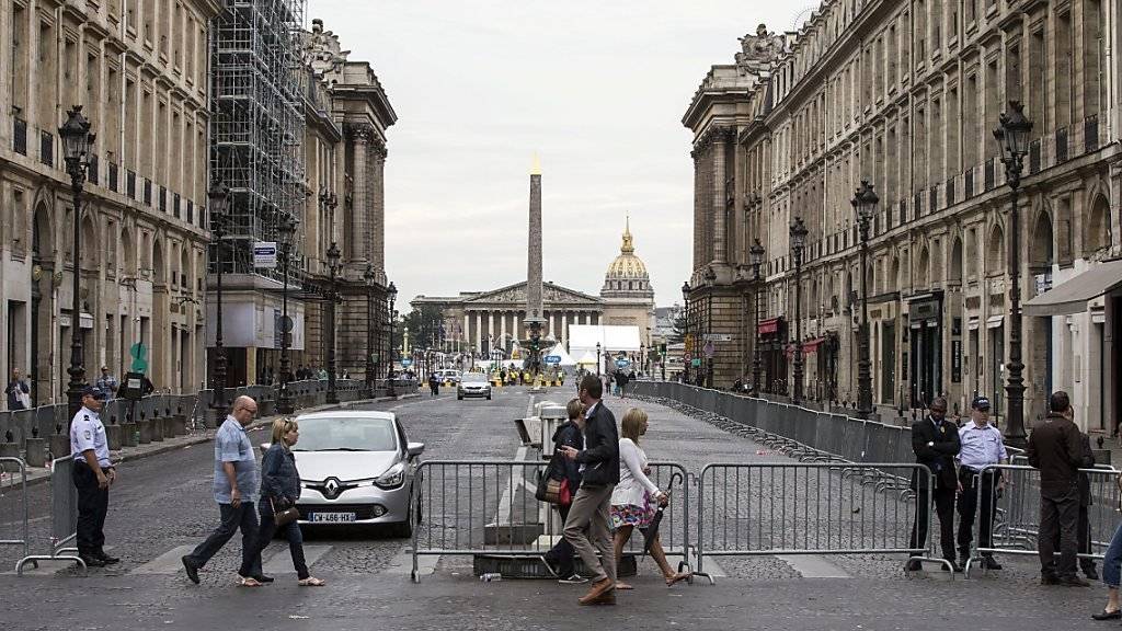Polizisten bewachen vor der ankunft der Tour de France die Absperrung an der Place de la Concorde in Paris.
