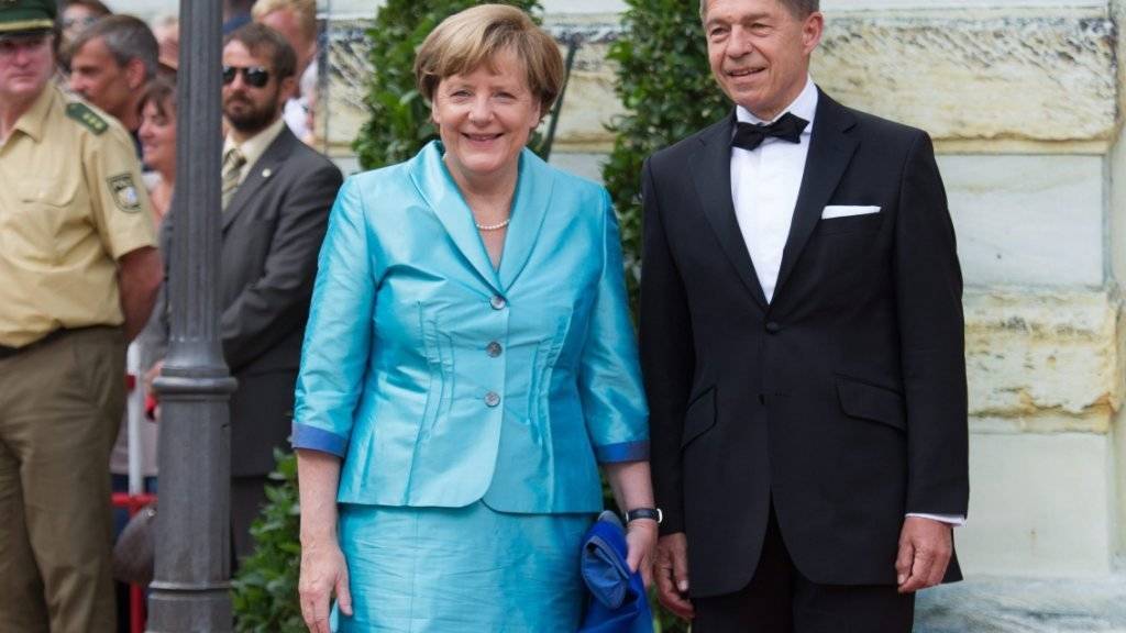 Deutschlands Kanzlerin Angela Merkel und ihr Ehemann Joachim Sauer lächeln bei der Eröffnung der Bayreuther Festspiele.