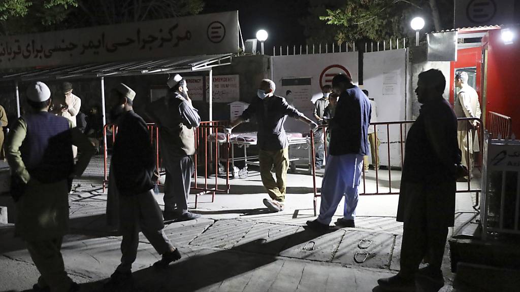 Afghanen warten vor dem Krankenhaus auf ihre Angehörigen. In Afghanistan detoniert eine massive Autobombe bei einem Gästehaus in der zentralen Provinz Logar. Unter den zahlreichen Opfern sind vor allem Schüler. Foto: Rahmat Gul/AP/dpa