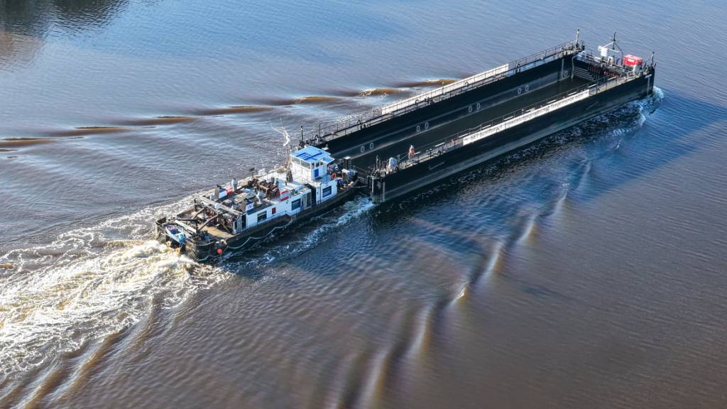Ein Lastkahn, geschoben von dem Schubschiff «Hans» fährt auf dem Nord-Ostsee-Kanal bei Hohenhörn. Die sogenannte Barge, die für den Transport des Wals durch die Ostsee in die Nordsee vorgesehen ist, soll kommende Nacht oder Montagfrüh an der Insel Poel ankommen. (Aufnahme mit einer Drohne) Foto: Bodo Marks/dpa