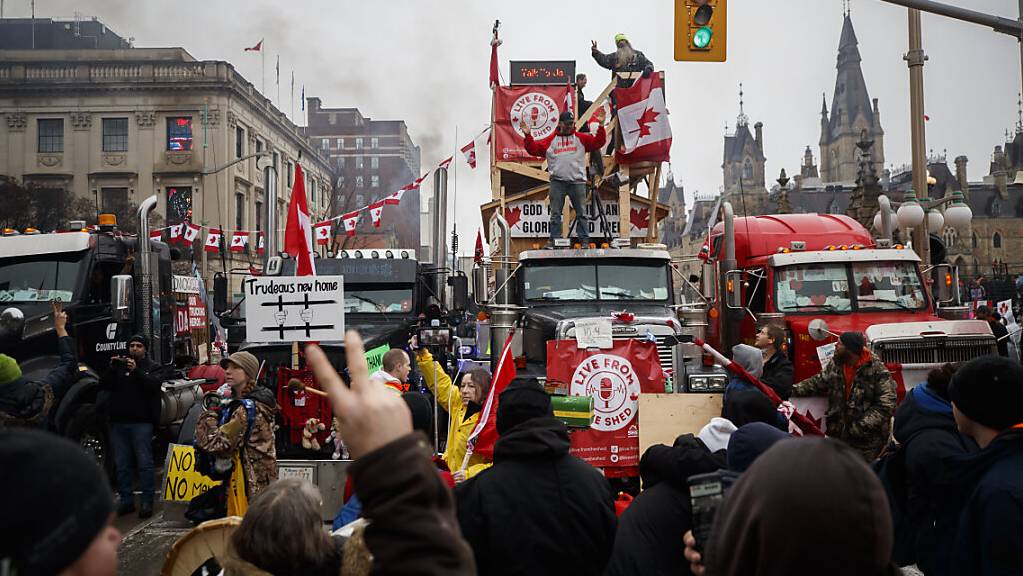 Demonstranten und Unterstützer versammeln sich um Rednern zuzuhören. Foto: Cole Burston/The Canadian Press/AP/dpa