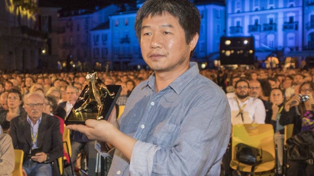 Der chinesische Regisseur Wang Bing mit seinem Goldenen Leoparden. Er war darüber genauso überrascht wie Kritiker und Publikum und hatte deshalb keine Dankesrede vorbereitet.