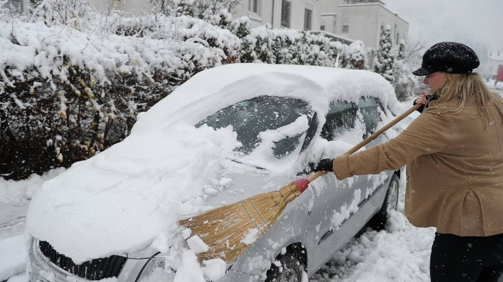 Da hilft nur noch der Griff zum Besen: Das Auto vom Schnee zu befreien ist oftmals ein Kraftakt.