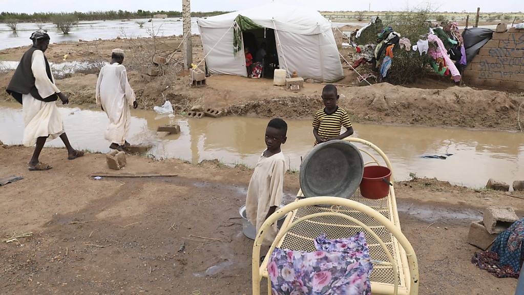 Zwei kleine sudanesische Jungen stehen vor ihrer provisorischen Unterkunft am Strassenrand, etwa 60 Kilometer von der Hauptstadt entfernt. Sintflutartige Regenfälle haben Häuser und die Infrastruktur im ganzen Land verwüstet.