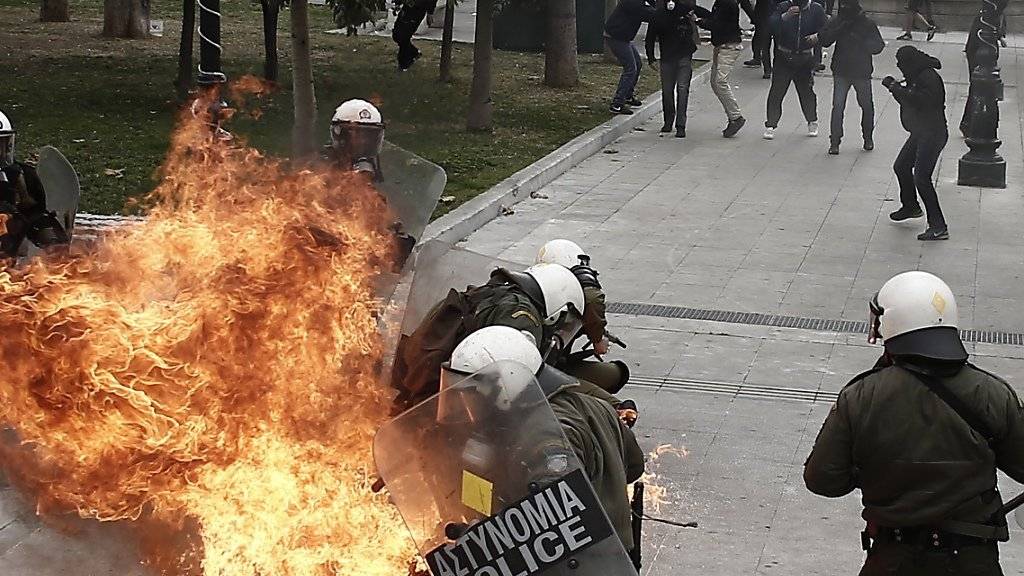 Linksautonome werfen während des Generalstreiks in Athen einen Molotow-Cocktail auf Polizisten.