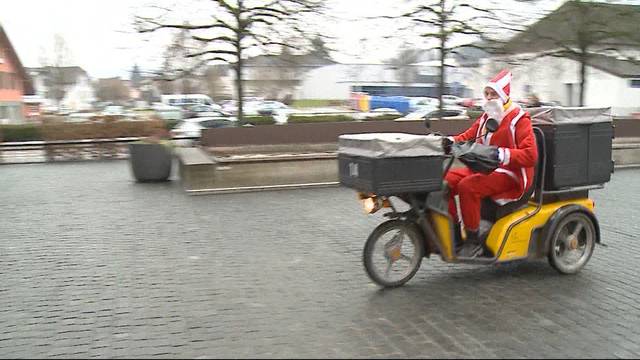 Weihnachtsmann verteilt Päckli mit Töff