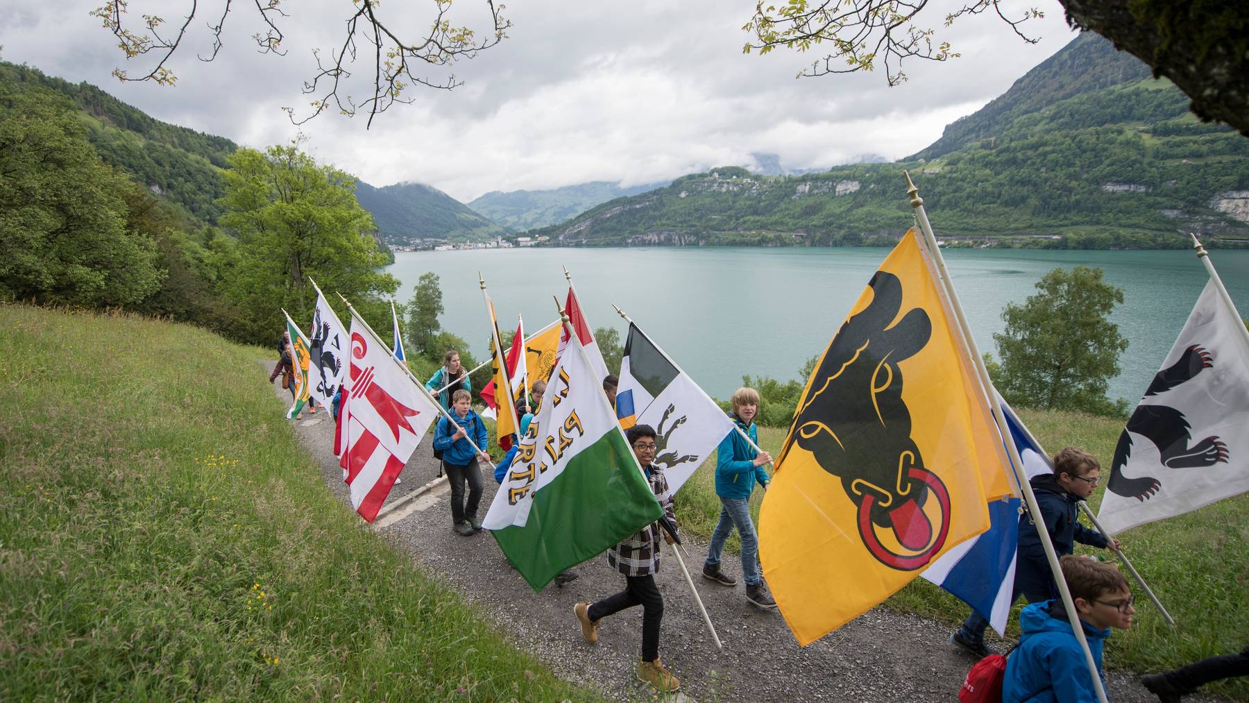 Schulkinder mit Kantonsfahnen auf dem «Weg der Schweiz» aus Anlass des 25. Geburtstag des 1991 errichteten Zentralschweizer Wanderweg.