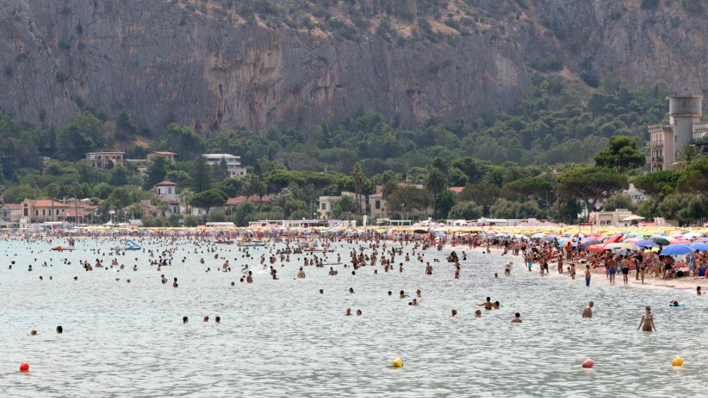Zahlreiche Menschen besuchen der Strand von Mondello in der Nähe der Stadt Palermo. Die Hitzewelle in Süditalien mit Temperaturen von bis zu 45 Grad Celsius hält weiter an. Foto: Alberto Lo Bianco/LaPresse via ZUMA Press/dpa