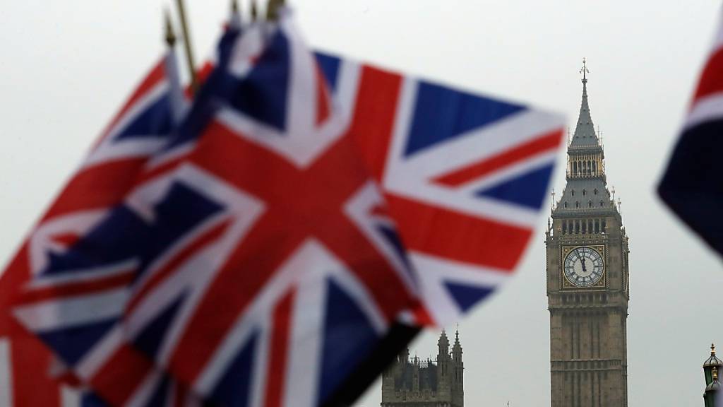 ARCHIV - Britische Flaggen wehen in der Nähe des berühmten Uhrturms Big Ben. Der Uhrturm ist Teil des Palace of Westminster, in dem das britische Parlament tagt. Foto: Matt Dunham/AP/dpa
