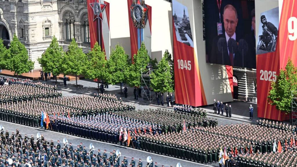 Russische Soldaten nehmen an der Militärparade zum Tag des Sieges teil. Anlass ist der 80. Jahrestag des Sieges der Sowjetunion über Nazi-Deutschland im Zweiten Weltkrieg. Auf dem Monitor wird die Rede von Russlands Präsident Putin gezeigt. Foto: Maxim Bogovid/Photo host agency RIA Novosti/AP/dpa