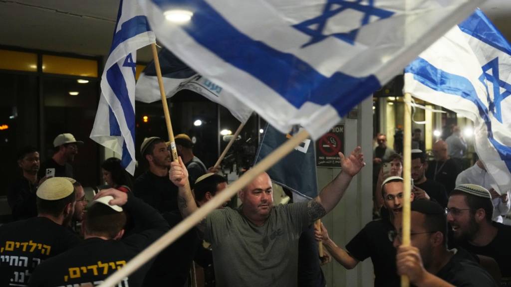 dpatopbilder - Menschen feiern am Ben-Gurion-Flughafen in der Nähe von Tel Aviv die Ankunft eines FlyDubai-Flugzeugs mit israelischen Passagieren an Bord, das zuvor in Saudi-Arabien notlanden musste. Foto: Ariel Schalit/AP/dpa