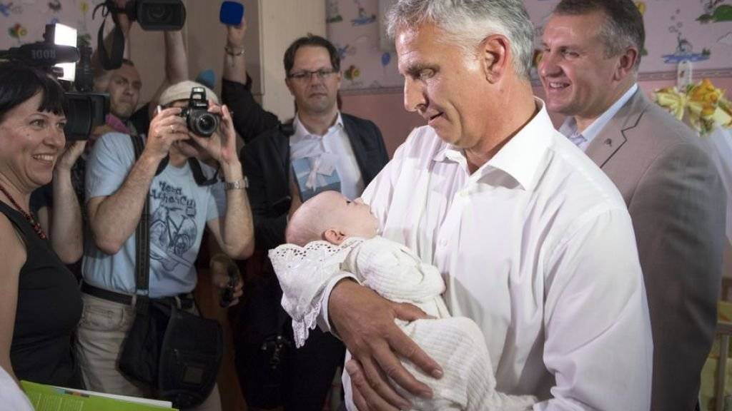 Didier Burkhalter - damals noch Aussenminister - vergangenen Juni mit einem ukrainischen Findelkind im Arm. (Archivbild)