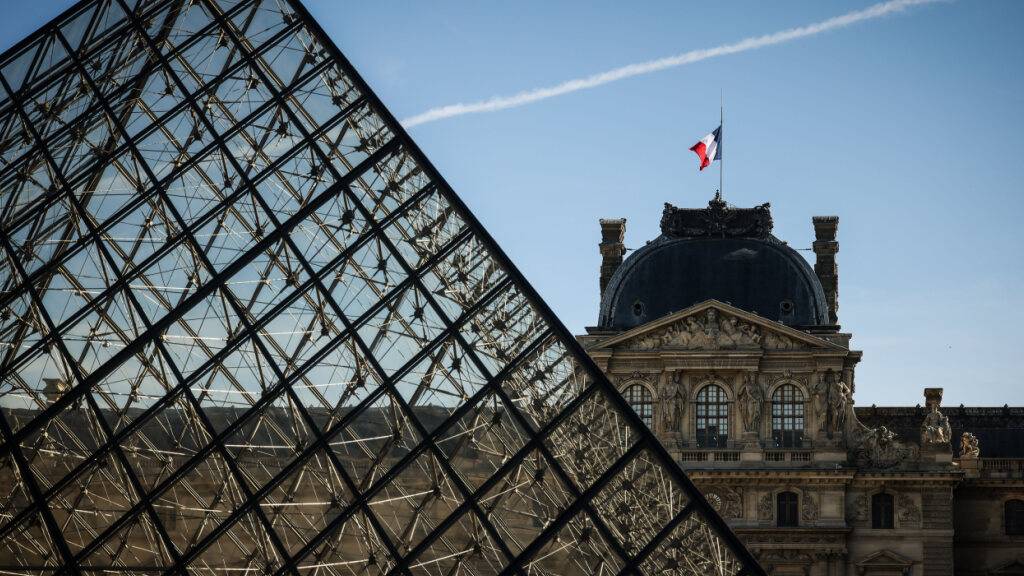 ARCHIV - Die französische Flagge weht auf dem Louvre-Museum. Der Louvre hat wegen der Proteste in Frankreich seine Türen zu Beginn der Woche nicht wie gewohnt geöffnet. Foto: Thomas Padilla/AP/dpa